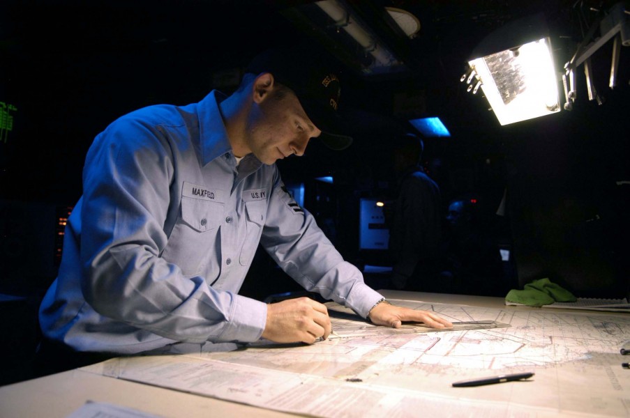 US Navy 040818-N-0499M-001 Operation Specialist 2nd Class Ryan E. Maxfield plots the ship^rsquo,s position on a navigational chart 