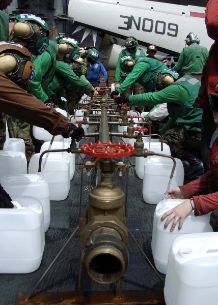 US Navy 050109-N-0057P-109 Crew members aboard USS Abraham Lincoln (CVN 72) fill jugs with purified water from a Potable Water Manifold