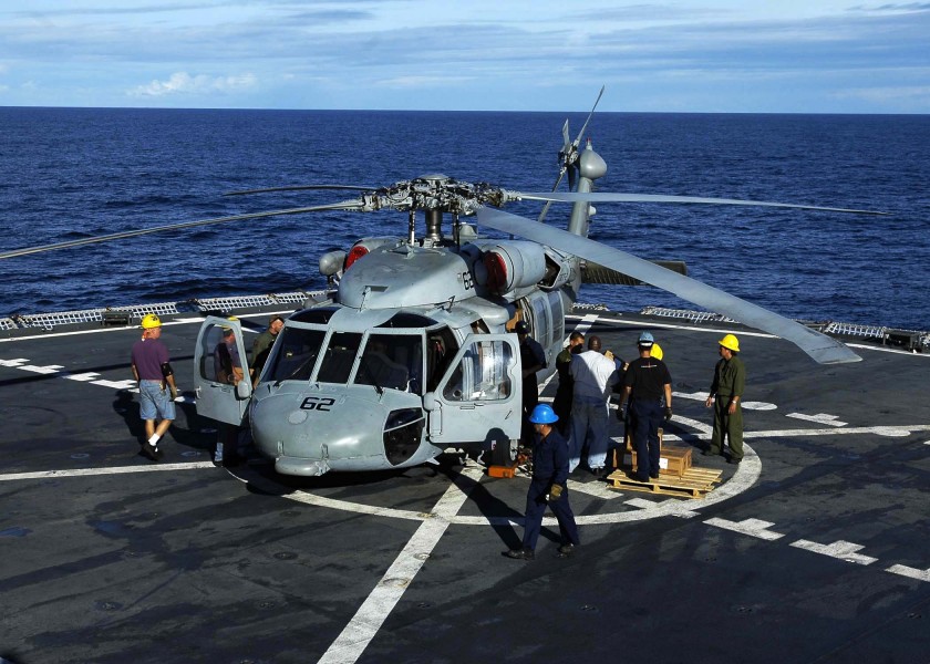 US Navy 050112-N-6074Y-015 Merchant Marine Sailors load a MH-60S Knighthawk helicopter with relief supplies prior to being flown to villages on the island of Sumatra, Indonesia
