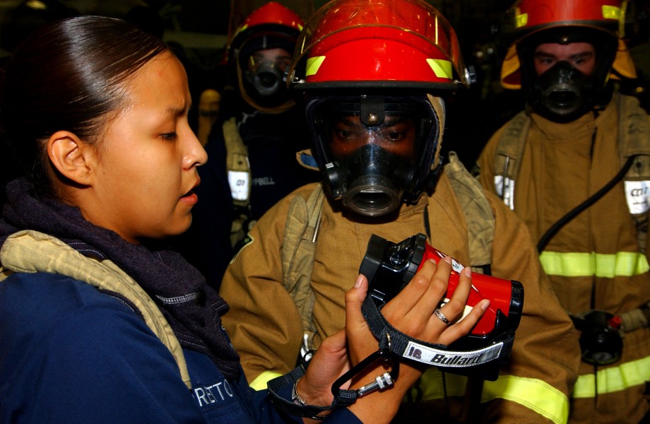 US Navy 050713-N-6125G-004 Damage Controlman 3rd Class Louchelle Loretto, left, trains a fire party on how to use the new Naval Firefighting Thermal Imager (NFTI) during a general quarters drill