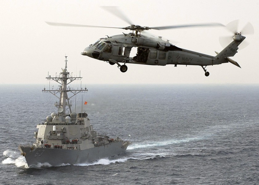 US Navy 060325-N-5837R-169 A MH-60S Seahawk helicopter assigned to the Golden Falcons of Helicopter Anti-Submarine Squadron Two (HS-2), flies by the guided-missile destroyer USS Russell (DDG 63)