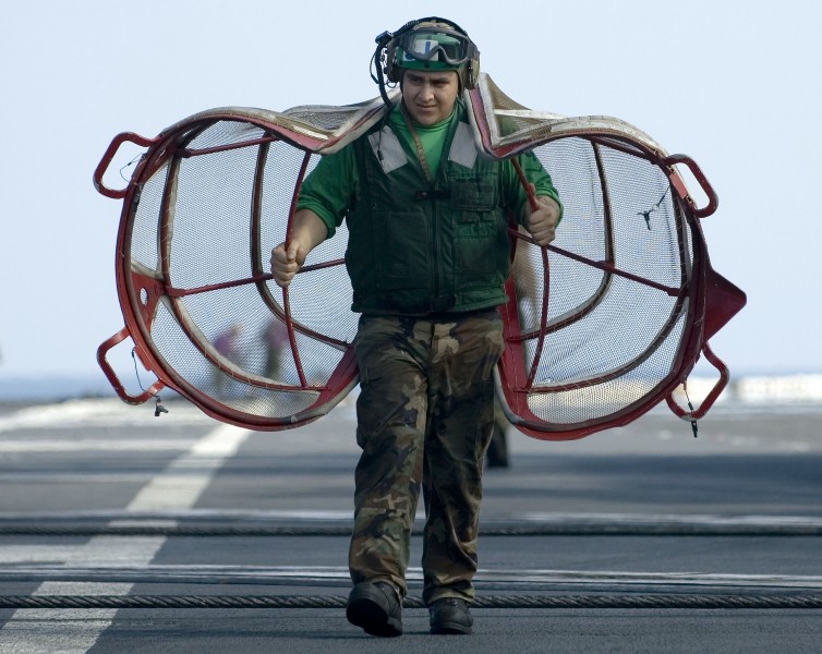US Navy 060416-N-4166B-045 A Sailor assigned to Air Department carries intake duct screens on the flight deck aboard the Nimitz-class aircraft carrier USS Abraham Lincoln (CVN 72)