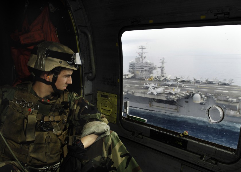 US Navy 060502-N-0499M-022 Lt. John C. Laney assigned to Explosive Ordnance Disposal Detachment 9, looks out the window of an SH-60F Seahawk helicopter