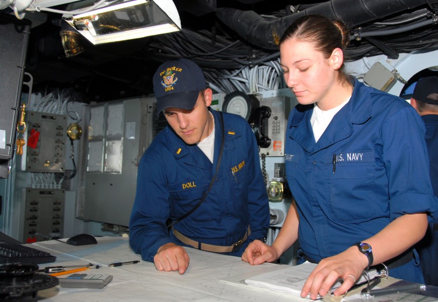 US Navy 070418-N-9689V-006 Ensign Brandon Doll, reviews the ship's position with Quartermaster Seaman Apprentice Angela Stewart 