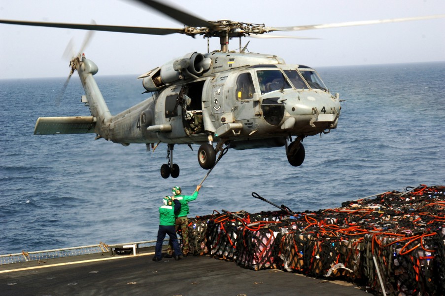 US Navy 070603-N-3262C-006 Sailors from Helicopter Squadron Combatant (HSC) 23 attach a hook to the bottom of an SH-60 Seahawk