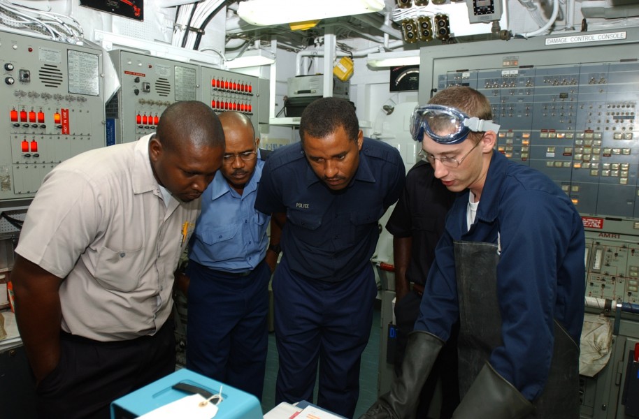 US Navy 080703-N-8943B-004 Gas Systems Turbine (Mechanical) Fireman James Smith explains an engineering system to members of the St. Lucia Marine Police