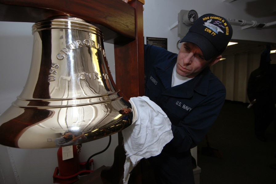 US Navy 090107-N-5658B-011 Boatswain's Mate Seaman Apprentice Charles Norris polishes a bell aboard the ceremonial quarterdeck of USS George H.W. Bush (CVN 77)