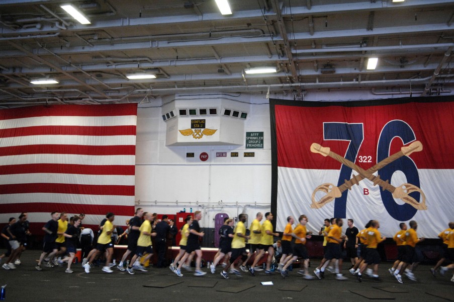 US Navy 090913-N-9818V-065 Sailors aboard the aircraft carrier USS Ronald Reagan (CVN 76) conduct morning physical training in the hangar bay of the ship