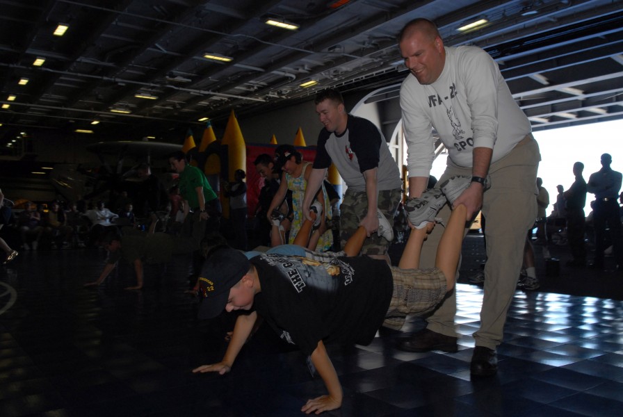 US Navy 091016-N-5586R-177 Sailors and Tiger Cruise participants compete in a wheelbarrow race aboard the aircraft carrier USS Ronald Reagan (CVN 76)