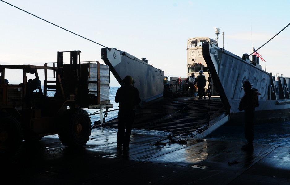 US Navy 100201-N-1831S-062 Sailors from Landing Craft Unit (LCU) 1663, assigned to Assault Craft Unit (ACU) 2, load supplies during a stern gate marriage with the amphibious assault ship USS Bataan (LHD 5)
