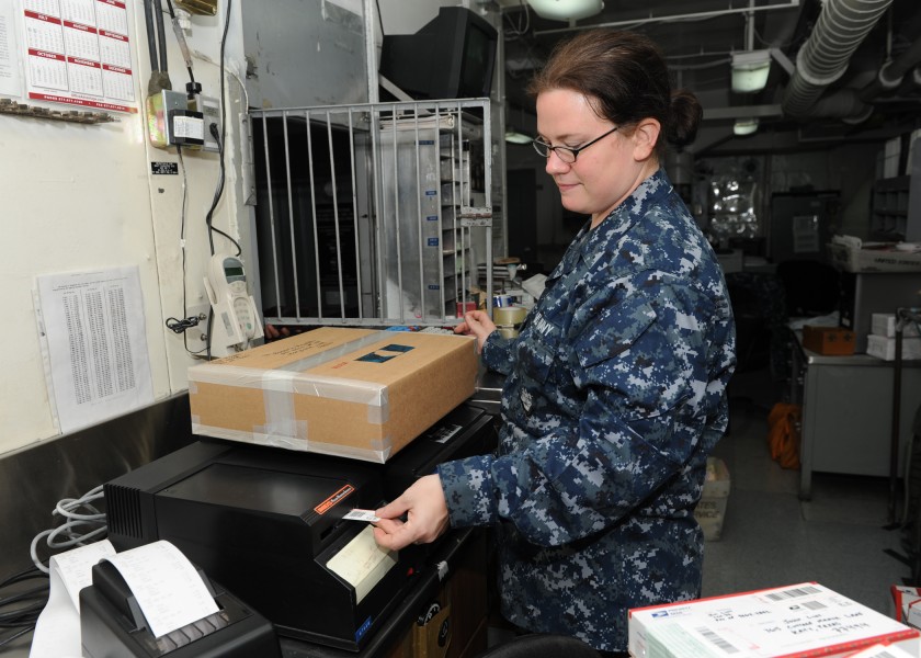 US Navy 101012-N-4997L-042 Logistic Specialist Seaman Gina Bartlow, from Montezuma, Ind., weighs a package in the post office of the aircraft carri