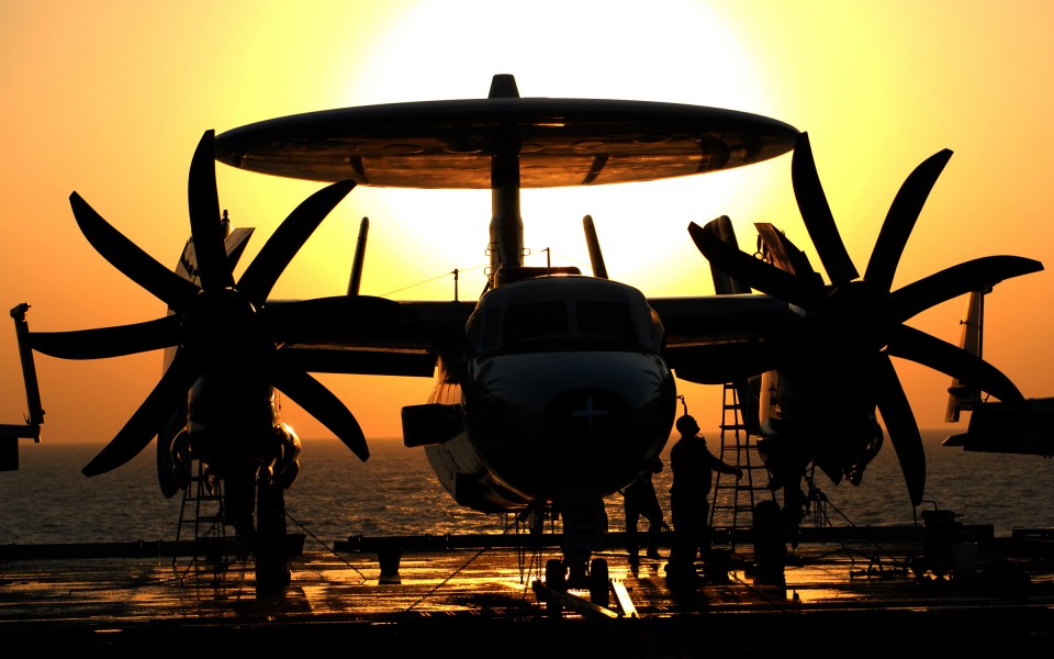US Navy 101112-N-8824M-051 Sailors assigned to the Sun Kings of Airborne Early Warning Squadron (VAW) 116 work on an E-2C Hawkeye at sunset aboard 