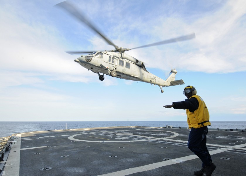 US Navy 110217-N-9793B-186 Boatswain's Mate 2nd Class Tyrone Williams directs an MH-60S Sea Hawk helicopter assigned to Helicopter Sea Combat (HSC)