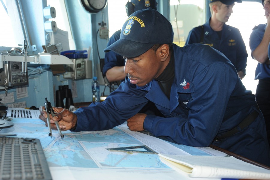 US Navy 110320-N-8497H-009 Quartermaster 1st Class Don Holt uses a protractor to check the ship's course aboard the mine countermeasures ship USS A
