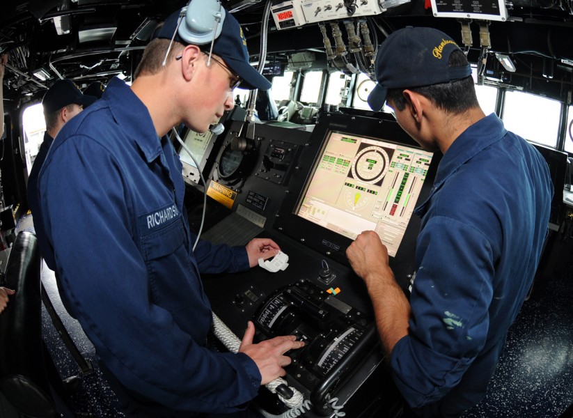 US Navy 110517-N-TB177-188 Gas Turbine System Technician (Electrical) Fireman Matt R. Richardson, left, receives training at the helm aboard USS Tr