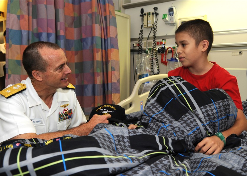 US Navy 110726-N-QN972-003 Rear Adm. Troy Shoemaker, commander of the Abraham Lincoln Carrier Strike Group, presents a ball cap to a patient at the