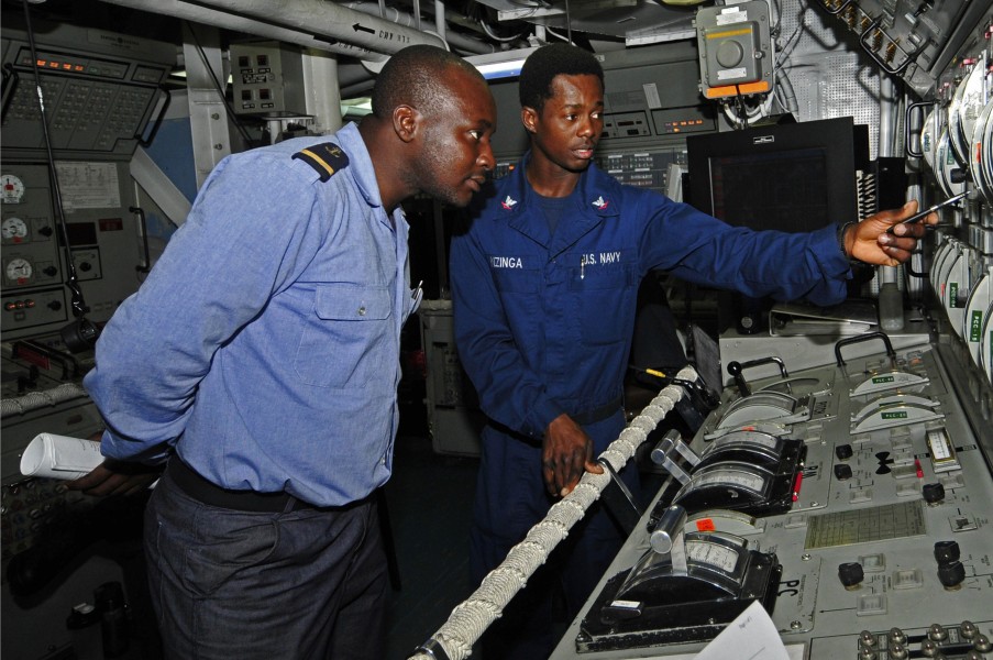 US Navy 120209-N-IZ292-079 Gas Turbine System Technician (Mechanical) 3rd Class Botha Nzinga explains the propulsion control console aboard the gui