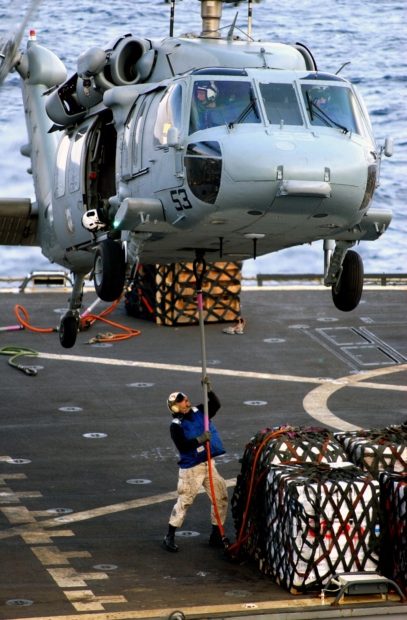 US Navy 030206-N-5821P-009 A Sailor assigned to the combat stores ship USNS San Jose (T-AFS 7) attaches a hoist line to the bottom of an SH-60 ^ldquo,Seahawk^rdquo, 