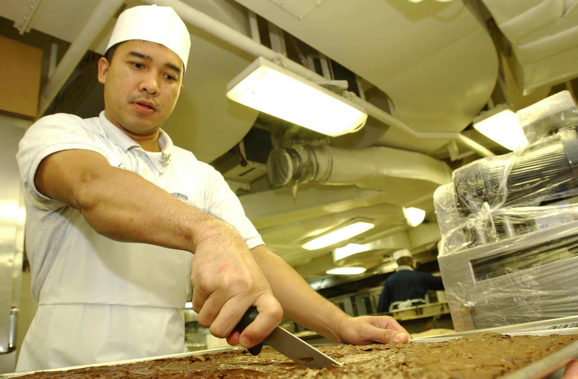 US Navy 030405-N-4768W-016 Mess Management Specialist 3rd Class Jess Vistro, from Oxnard, Calif., prepares chocolate brownies for the crew