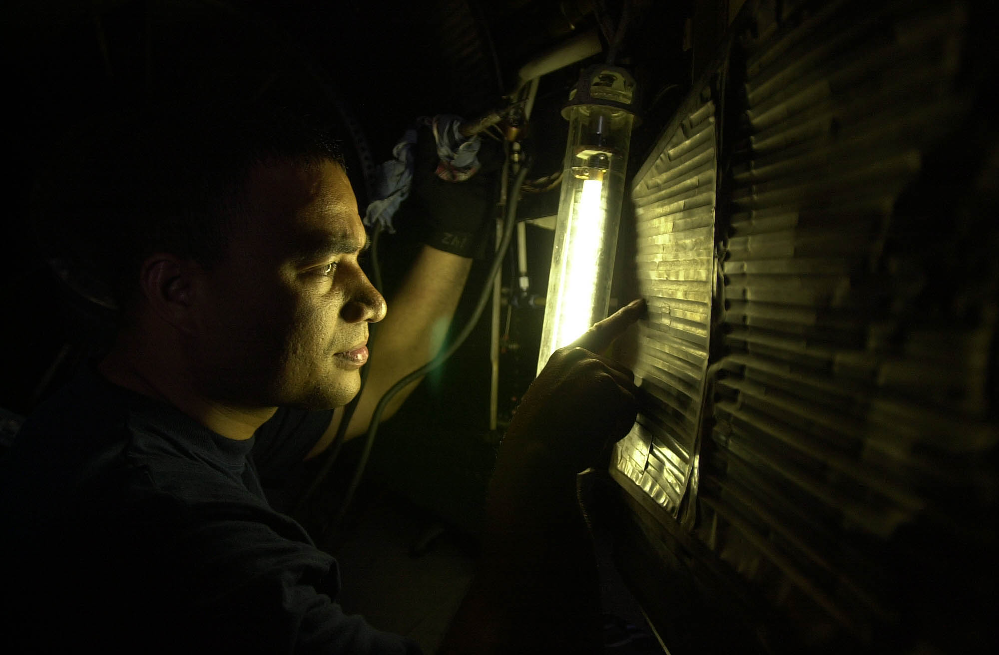 US Navy 030801-N-0413R-002 Aviation Machinist^rsquo,s Mate 3rd Class Ricky Clarence, inspects the heat shield of an aircraft aboard USS Nimitz (CVN 68)