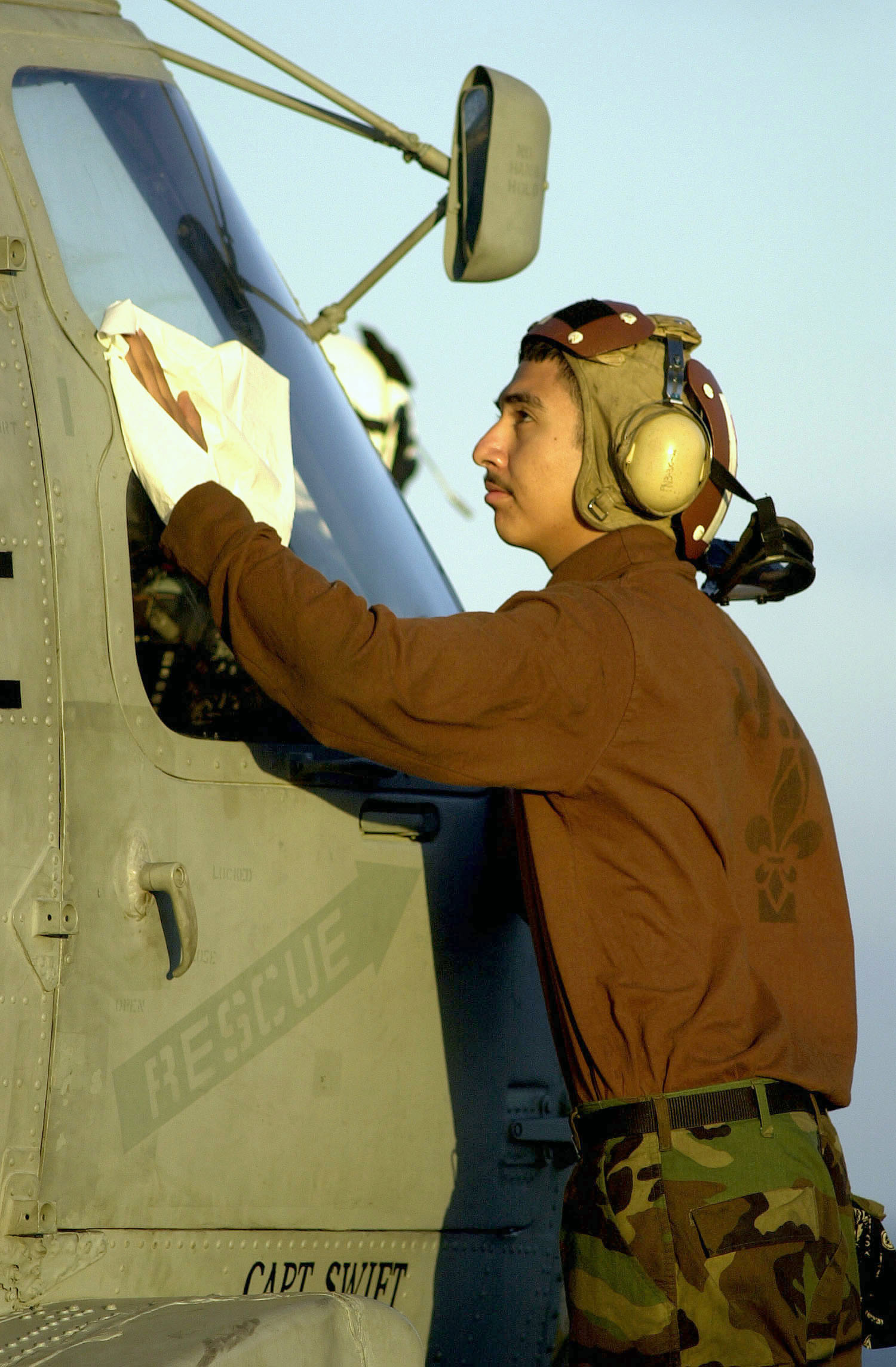 US Navy 030802-N-6213R-460 Aviation Machinist's Mate Airman Jose Padilla cleans the windshield of an SH-60F Seahawk