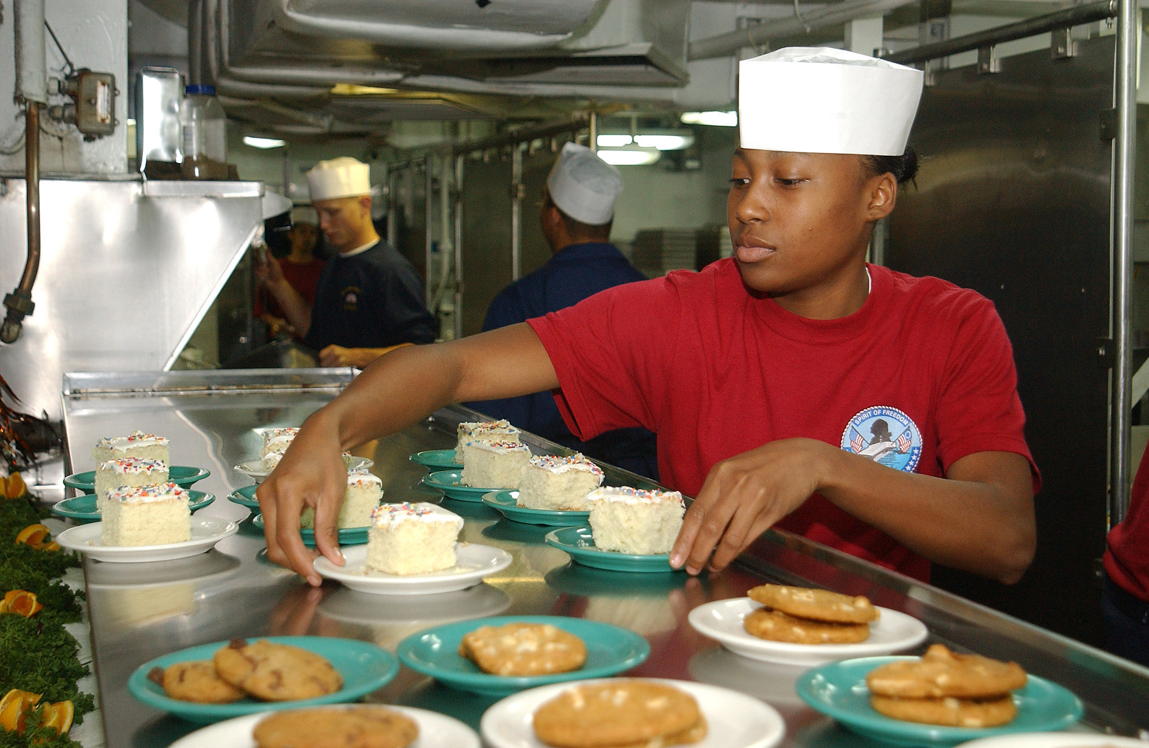 US Navy 031020-N-1127G-001 Seaman Elivian Clark, from Atlanta, places desserts out on the chow line aboard USS George Washington (CVN 73)