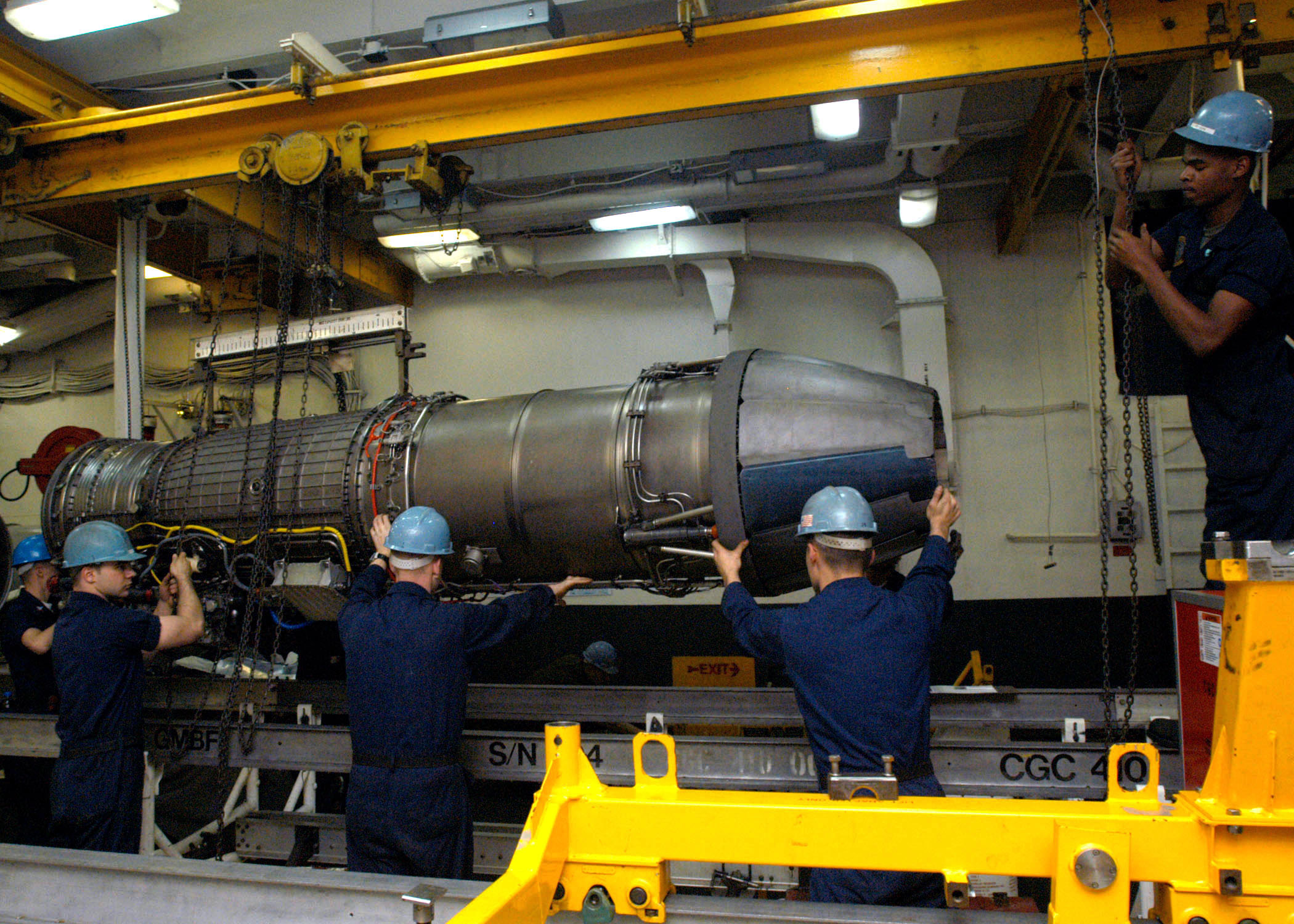 US Navy 040104-N-7278A-003 Personnel from the Aircraft Intermediate Maintenance Department (AIMD) prepare to place a jet engine onto an installation trailer aboard USS Enterprise (CVN 65)