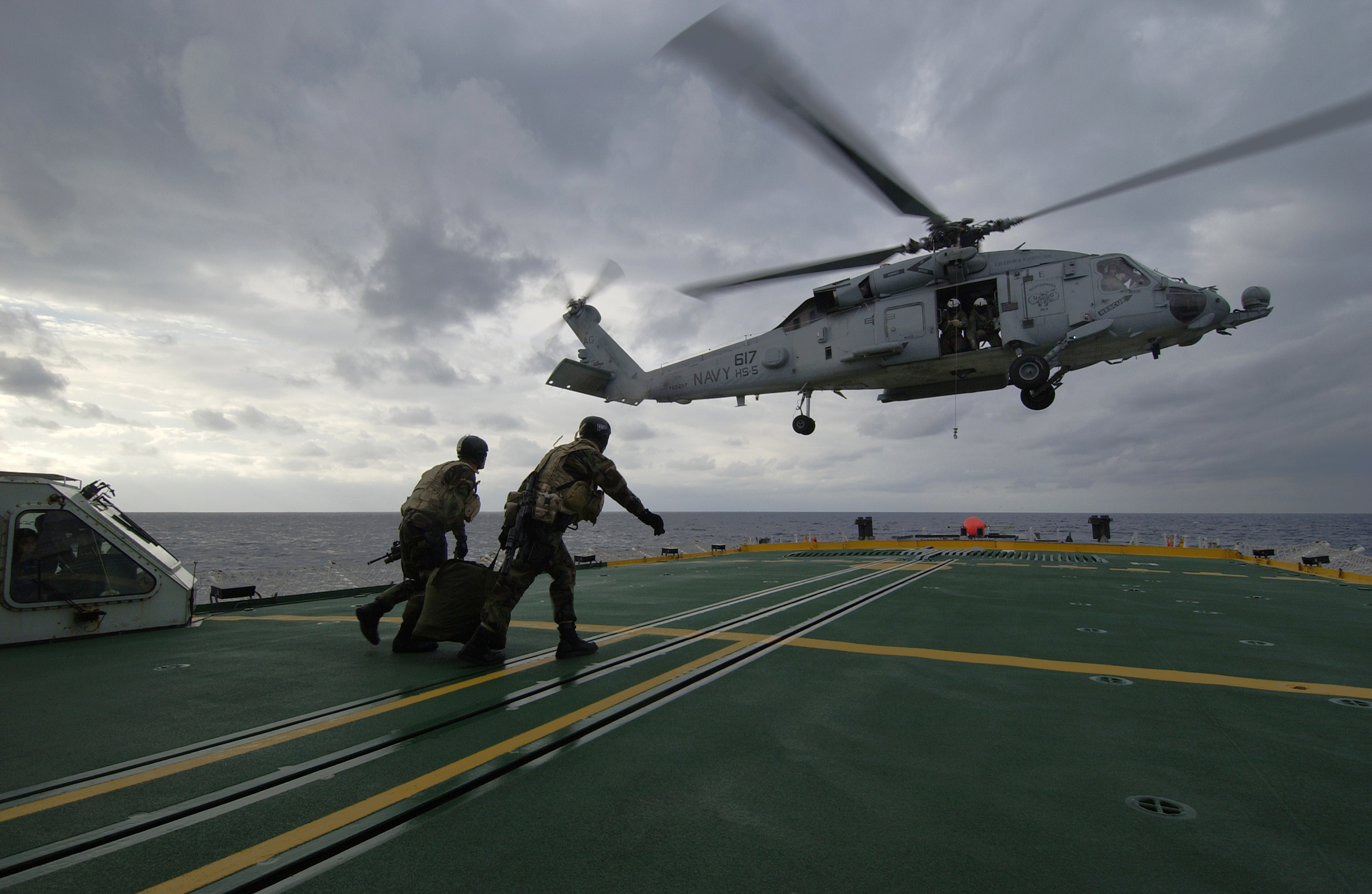 US Navy 040212-N-5319A-007 Members assigned to Explosive Ordnance Disposal Mobile Unit Six (EODMU 6) carry their fast rope back to an HH-60H Seahawk helicopter