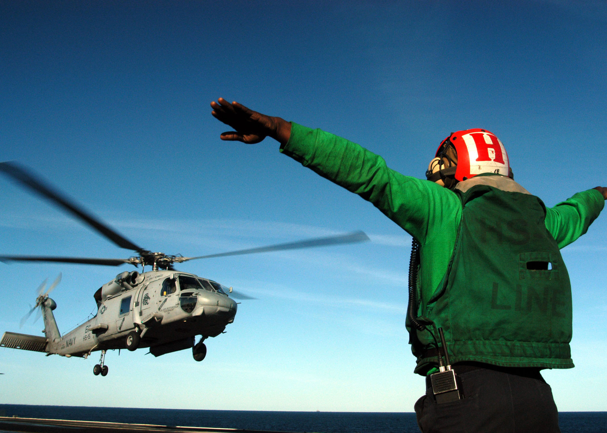 US Navy 040308-N-8704K-002 A Landing Signal Enlisted (LSE) signals an SH-60F Seahawk assigned to the 