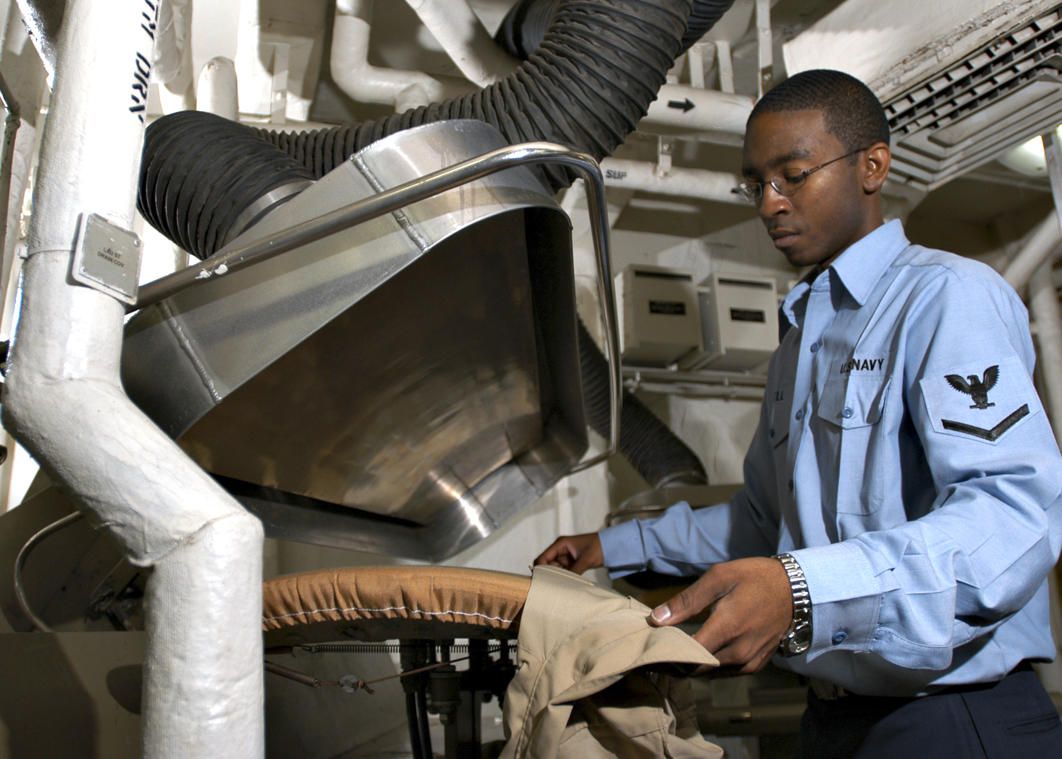 US Navy 040625-N-5952R-021 Ships Serviceman 3rd Class Justin Euell, from Camben, Miss., steam irons a shirt in the laundry room aboard the aircraft carrier USS Enterprise (CVN 65)