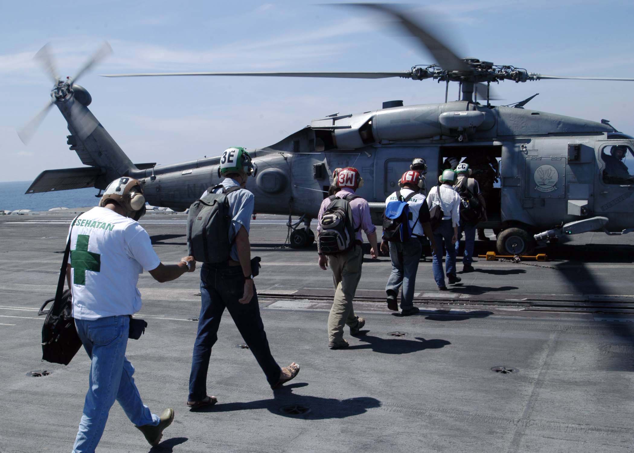 US Navy 050114-N-1229B-064 Military and United Nations personnel board an HH-60H Seahawk aboard USS Abraham Lincoln (CVN 72)