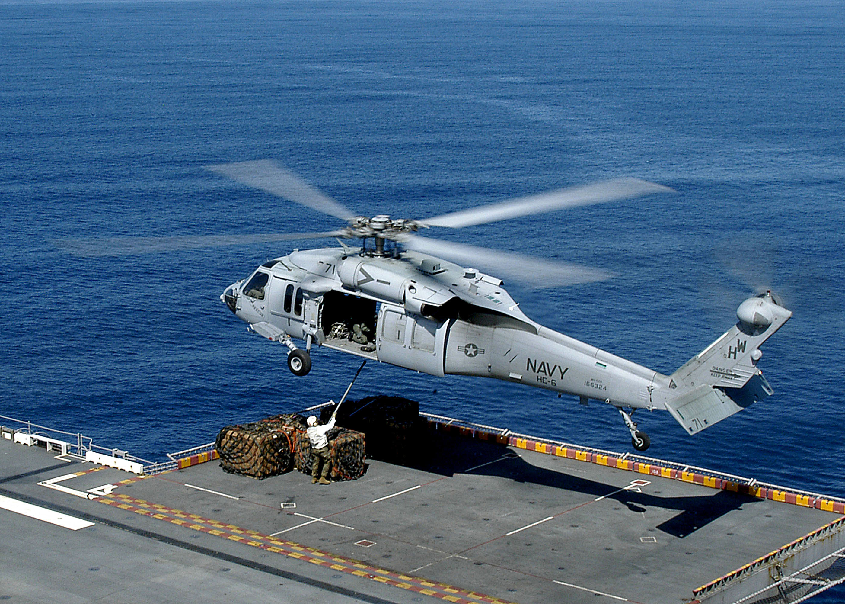 US Navy 050204-N-0050M-001 An MH-60S Knighthawk hovers above the flight deck of the amphibious assault ship USS Saipan (LHA 2)
