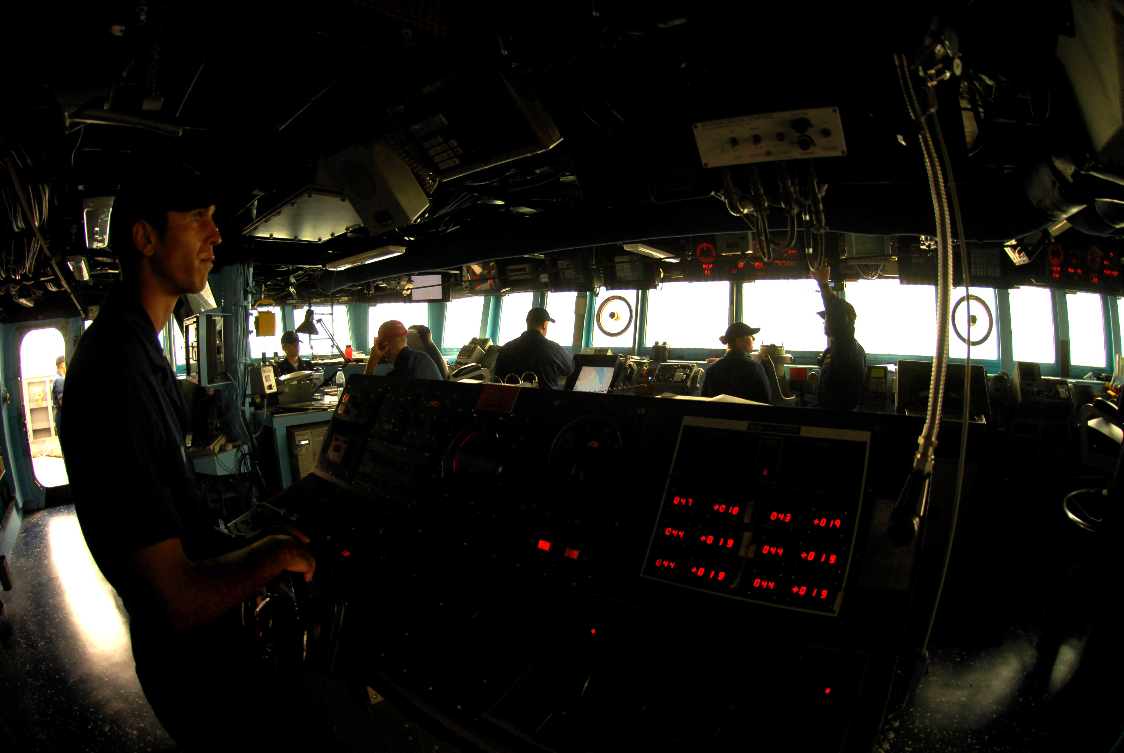 US Navy 070518-N-0684R-026 Seaman John Moen mans the helm during low visibility conditions caused by a sandstorm at sea aboard Arleigh Burke-class guided-missile destroyer USS Preble (DDG 88)