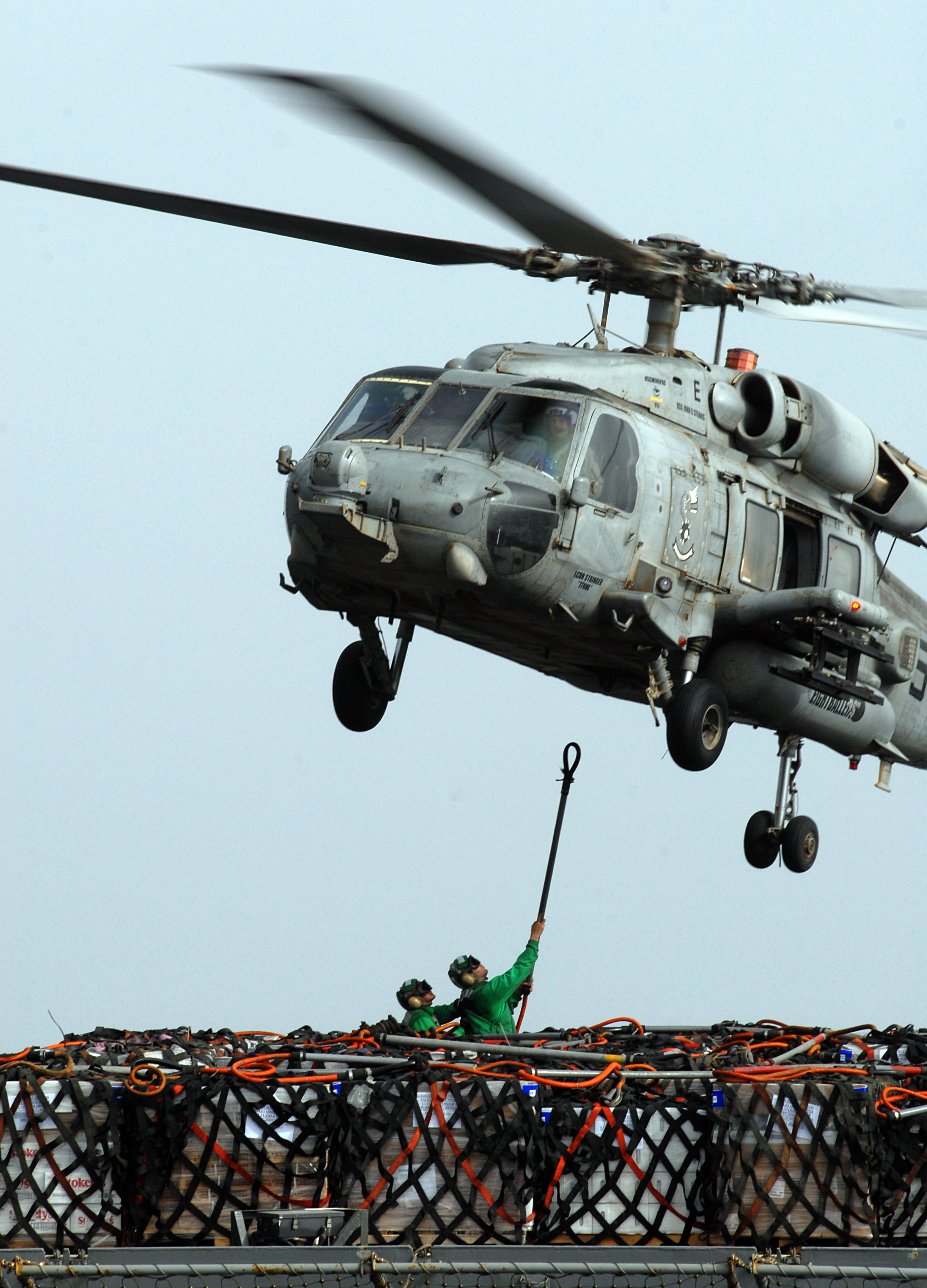 US Navy 070616-N-3038W-183 Sailors from Military Sealift Command fast combat support ship USNS Bridge (T-AOE 10) attach cargo nets holding pallets of supplies to an HH-60H Seahawk during a vertical replenishment