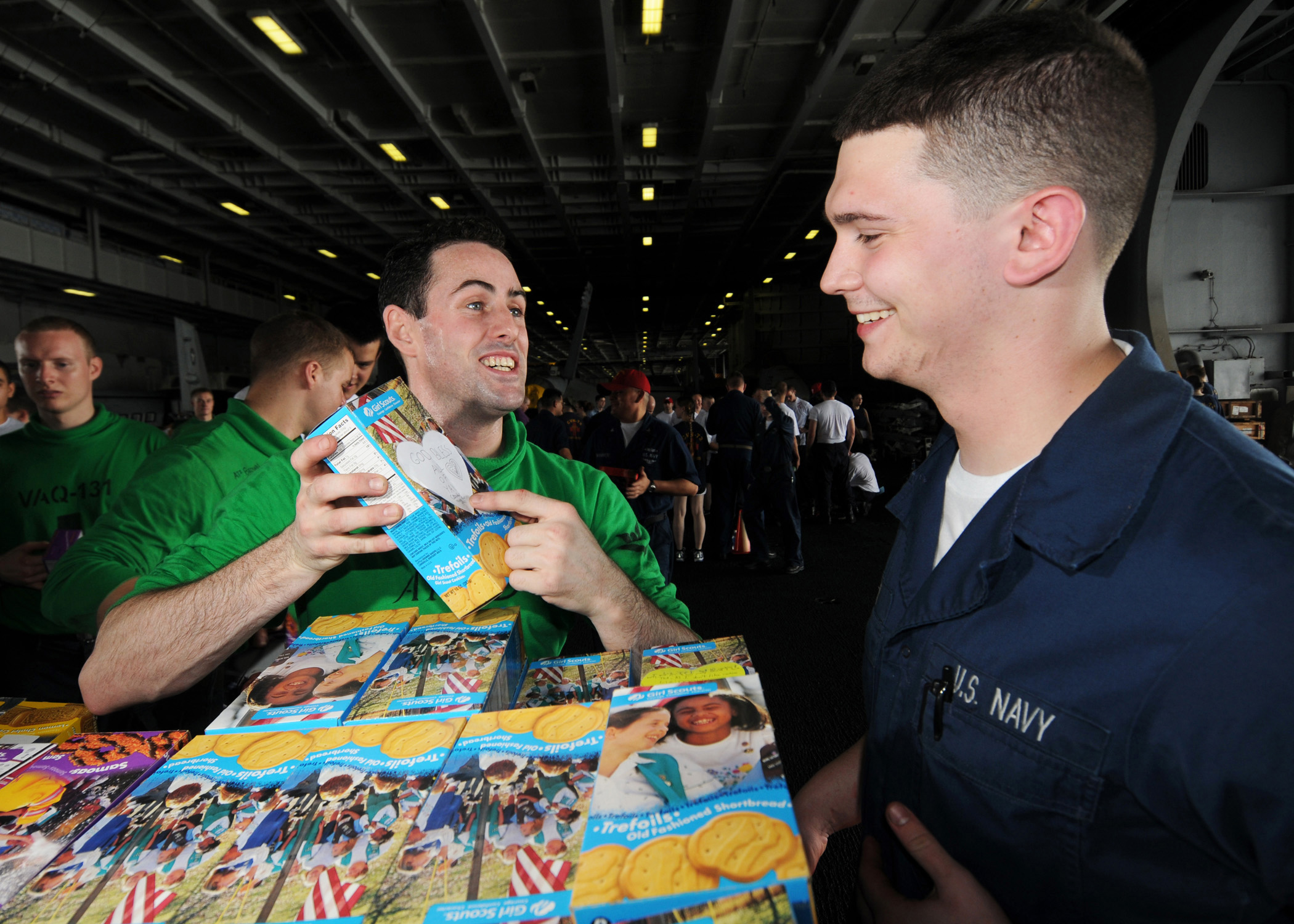 US Navy 080726-N-9898L-007 Aviation Electrician's Mate 3rd Class Stephan Riggs shows Ship's Serviceman Seaman Kevin Simak a note attached to a box of Girl Scouts cookies