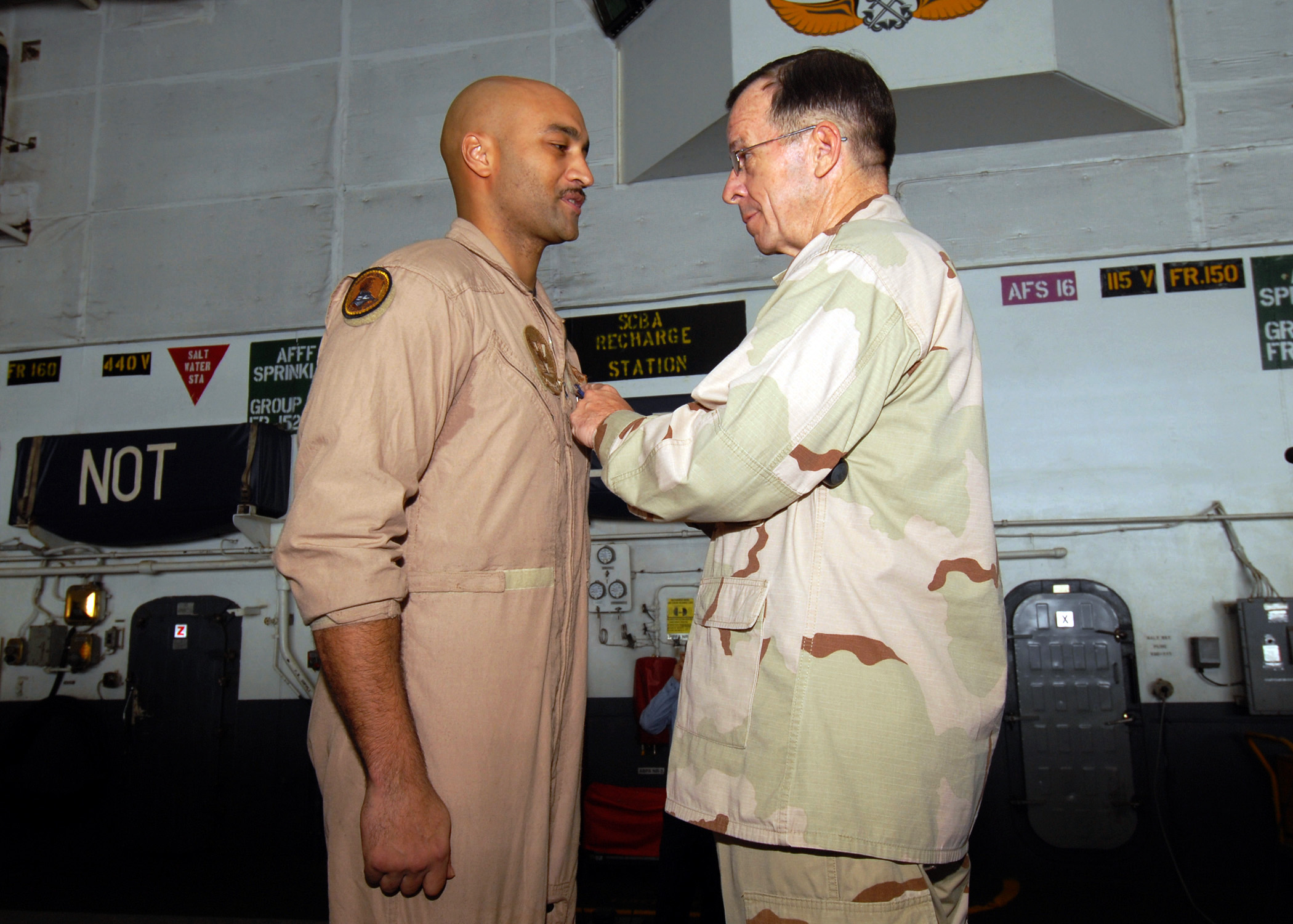 US Navy 080827-N-9079D-022 Chairman, Joint Chiefs of Staff Adm. Mike Mullen presents Aviation Warfare Systems Operator 1st Class Jesse P. Hubble with the Navy and Marine Corps Medal