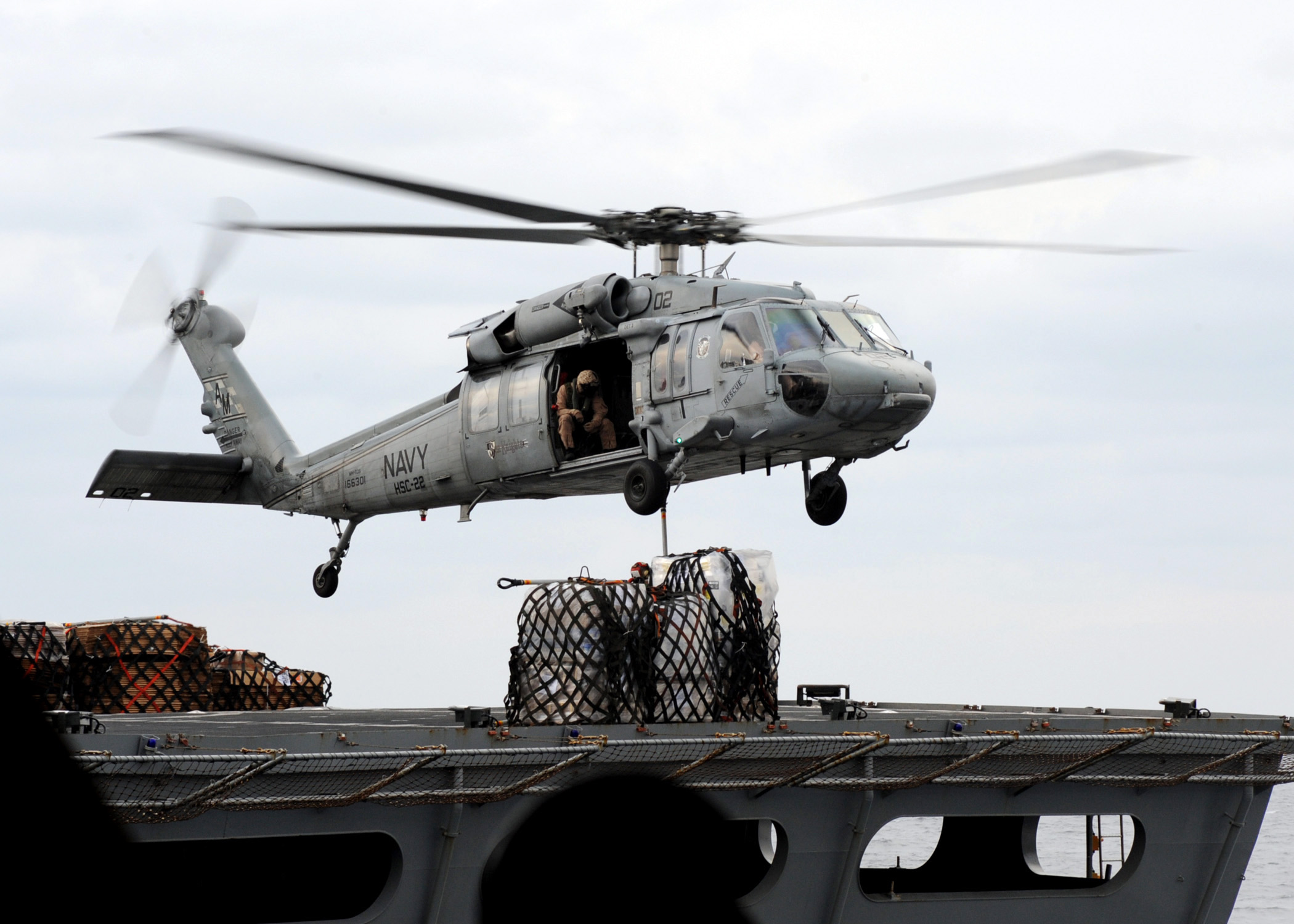 US Navy 090121-N-2562S-002 An MH-60S Sea Hawk helicopter transfers cargo makes a cargo pick-up during a replenishment at sea between the aircraft carrier USS Theodore Roosevelt (CVN 71) and USNS Supply (T-AOE 6)