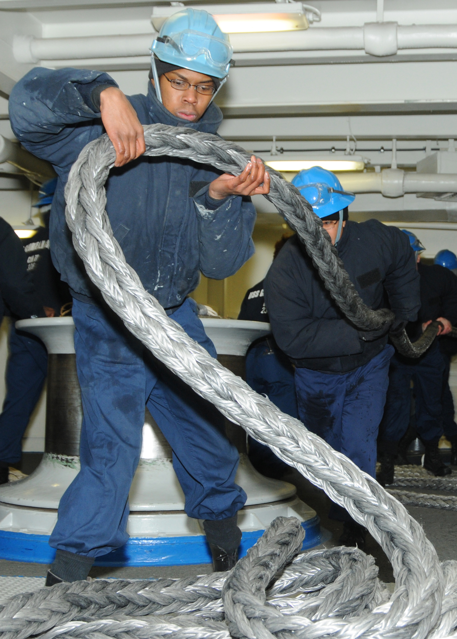 US Navy 100226-N-9793B-024 Seaman Antoin D. Gray takes in a mooring line in the ship's forecastle