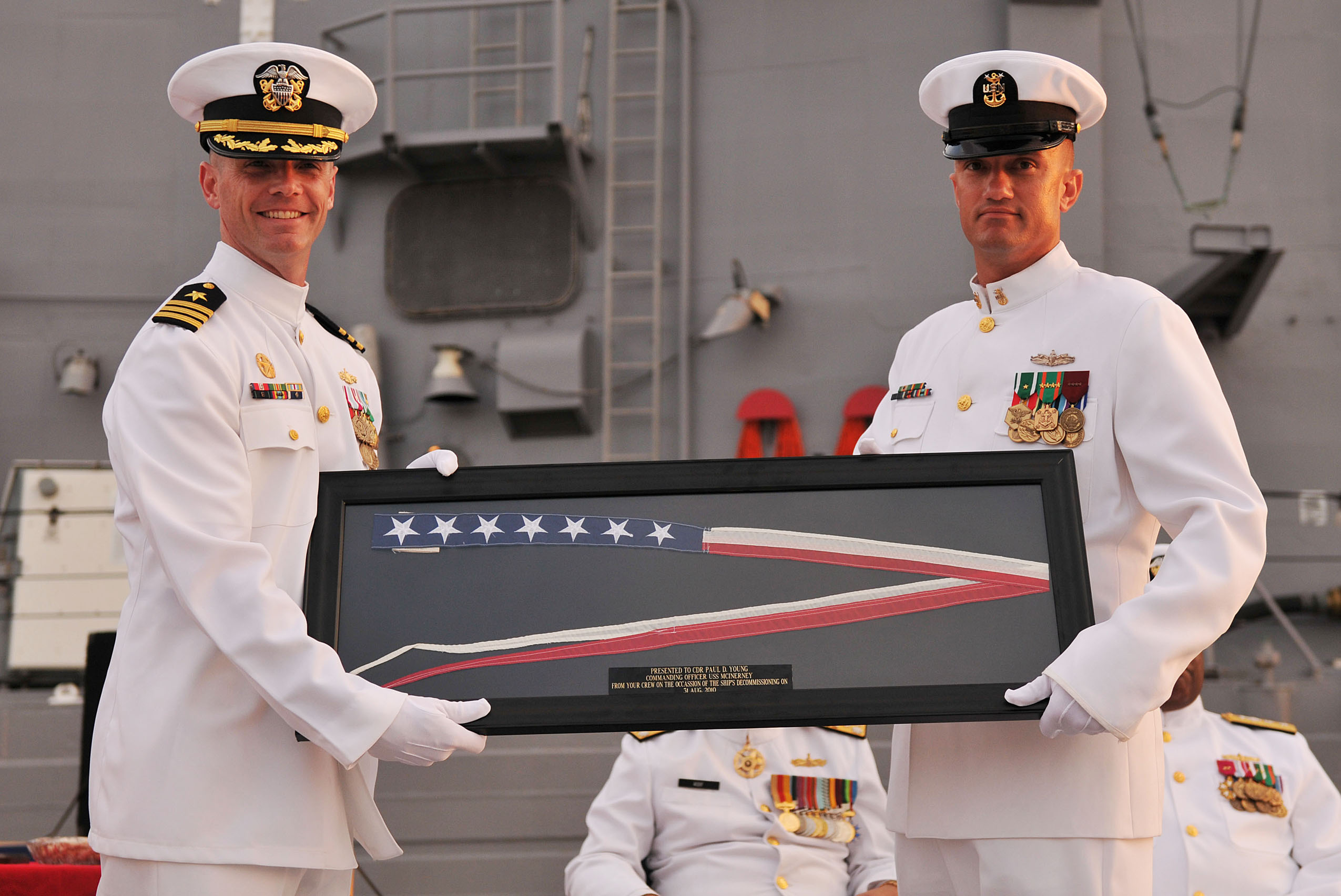US Navy 100831-N-8590G-010 Cmdr. Paul D. Young, left, receives the ship's commissioning pennant from Command Master Chief John Lawry during the decommissioning ceremony of USS McInerney (FFG 8)