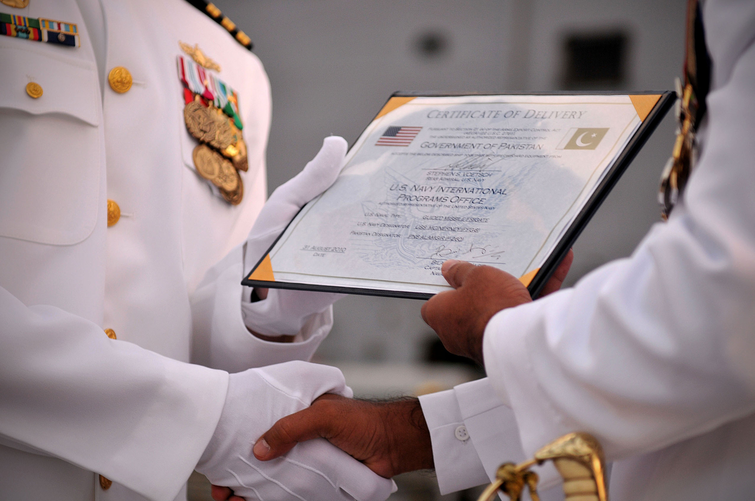 US Navy 100831-N-8590G-011 Cmdr. Paul D. Young presents a certificate of transfer to Capt. Naveed Ashraf during the of USS McInerney (FFG 8) at Naval Station Mayport