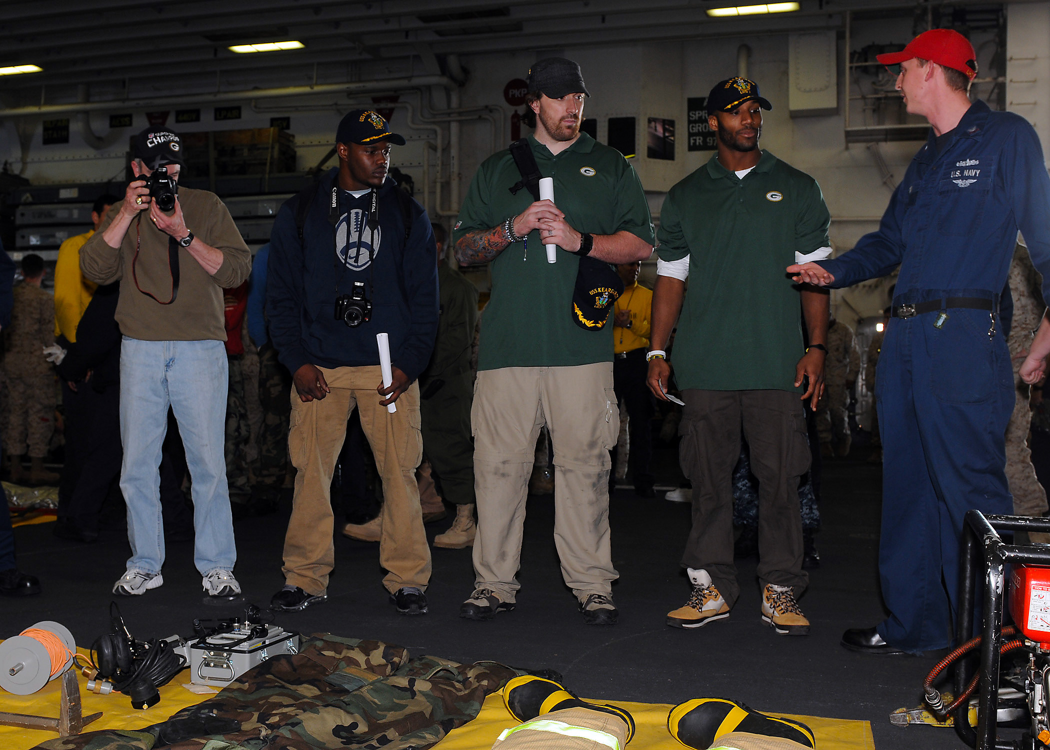 US Navy 110214-N-2908M-074 Super Bowl XLV champions, the Green Bay Packers, are briefed on fire fighting equipment by Damage Controlman 2nd Class S