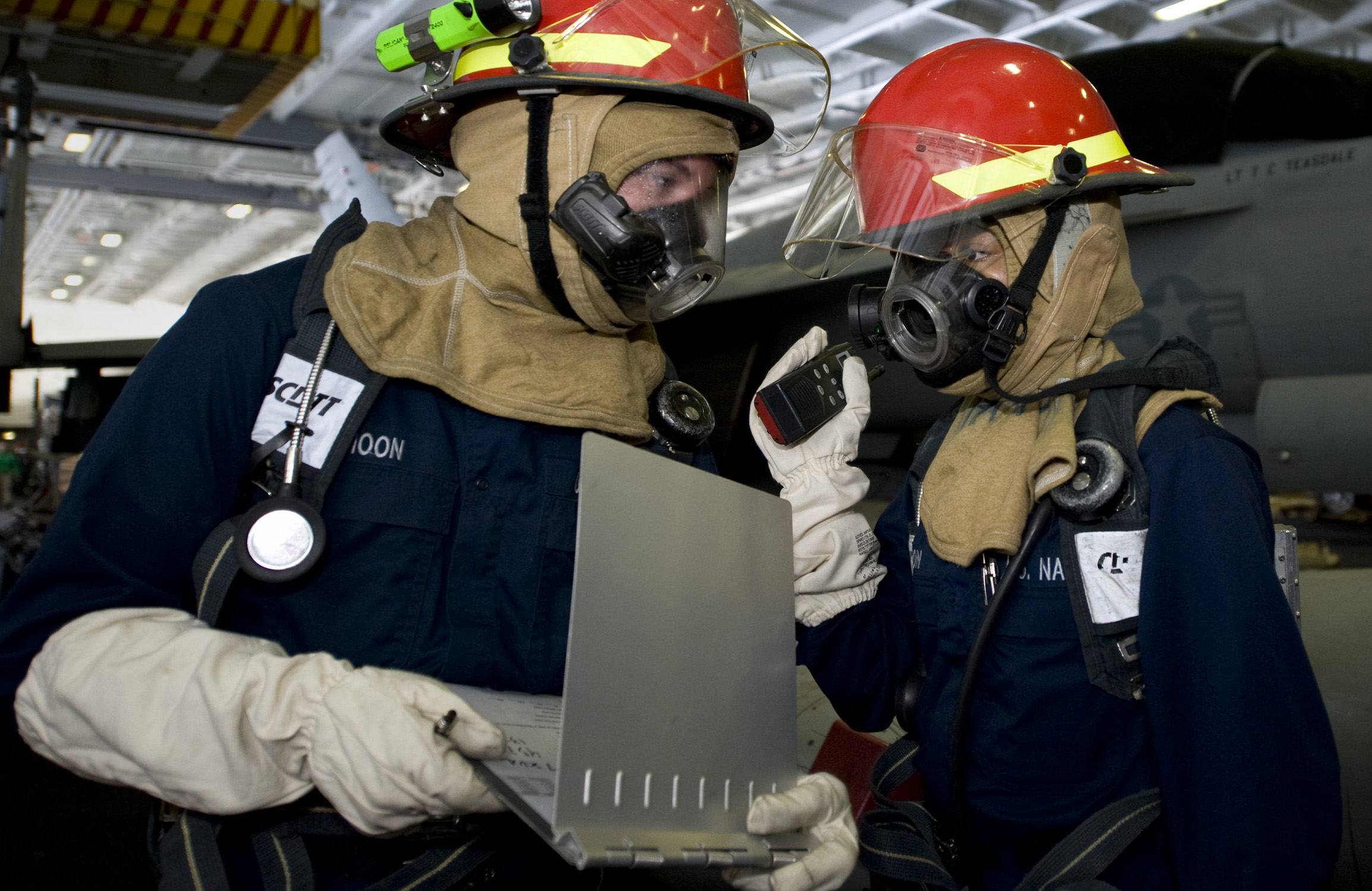 US Navy 111217-N-VO377-005 Sailors discuss fire-fighting strategy before entering a smoke-filled environment during a general quarters drill aboard