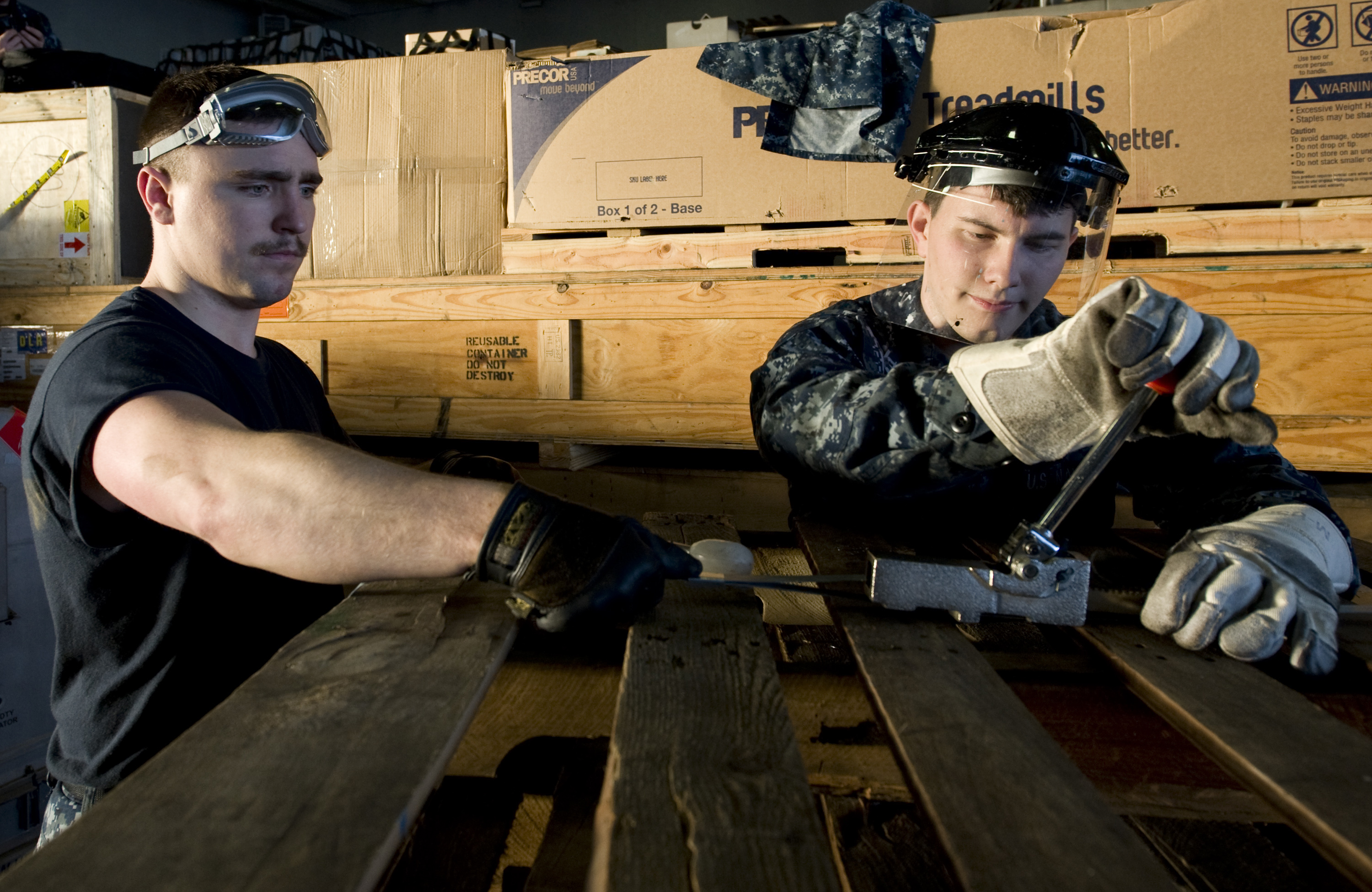 US Navy 111220-N-VO377-184 Sailors assigned to the Nimitz-class aircraft carrier USS Abraham Lincoln (CVN 72) bind empty pallets together during an