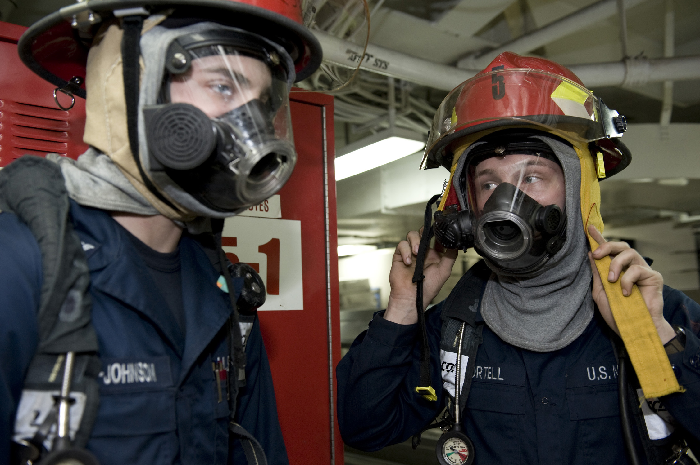 US Navy 111220-N-VO377-248 Sailors dress in full firefighting ensembles prior to battling a simulated fire during a general quarters drill aboard t