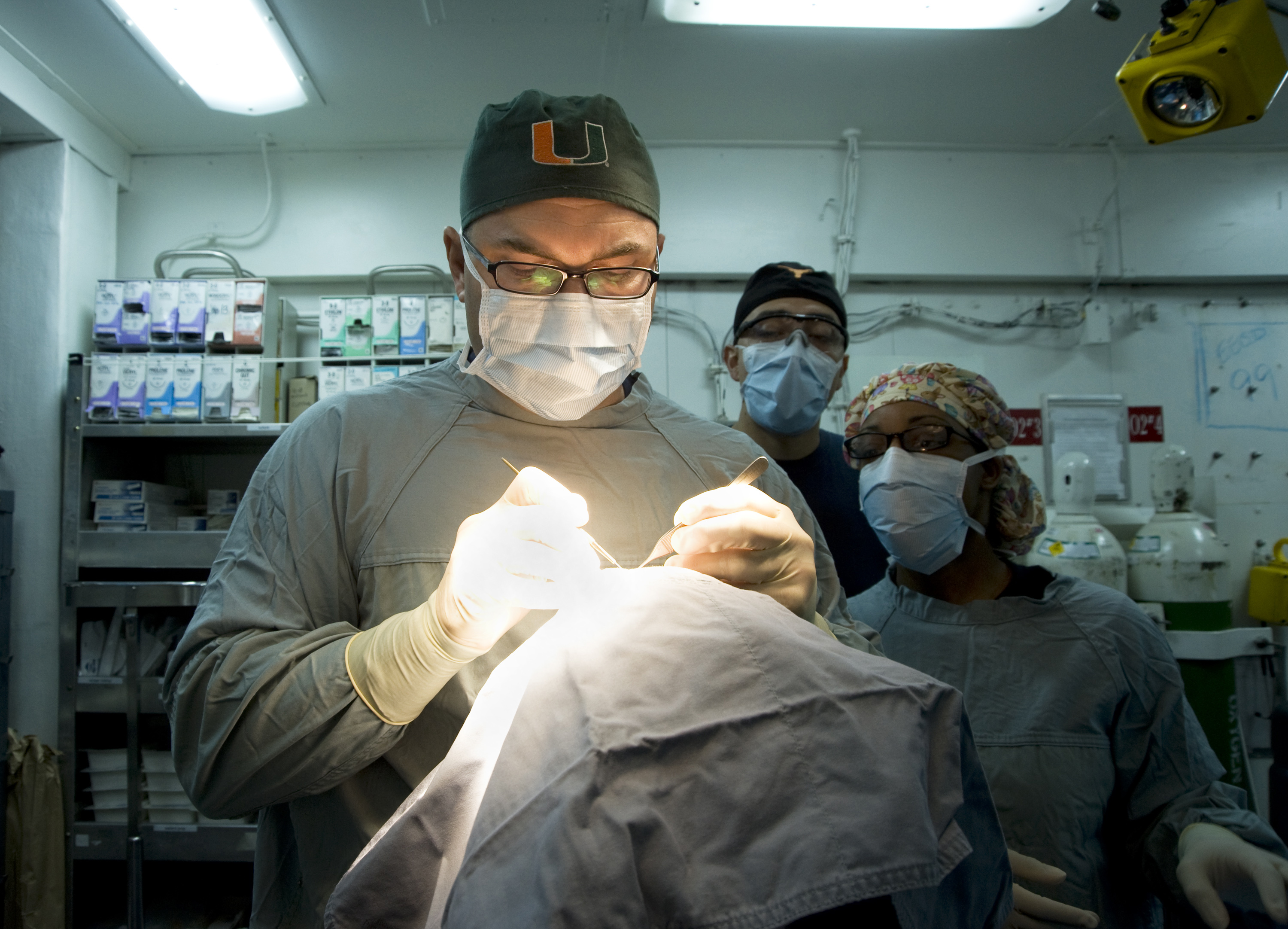 US Navy 120120-N-JN664-002 Lt. Cmdr. Howard Pryor, a Navy doctor, makes an incision into an epidermal inclusion cyst on the head of a patient in th