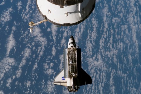 Backdropped by a blue and white Earth, the Space Shuttle Atlantis approaches the International Space Station during STS-117 rendezvous and docking operations. Docking occurred at 2:36 p.m. (CDT) on June 10, 2007. A pair of solar arrays and starboard truss segments (S3/S4), which are later to be attached to the station and outfitted during three spacewalks, can be seen in Atlantis' cargo bay. A docked Soyuz spacecraft is visible at top center.