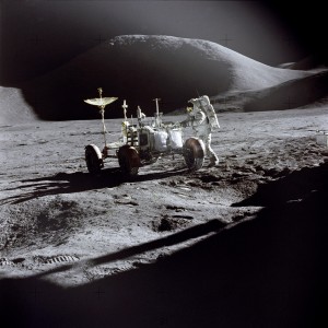 Astronaut James B. Irwin, Lunar Module pilot, works at the Lunar Roving Vehicle during the first Apollo 15 lunar surface extravehicular activity (EVA-1) at the Hadley-Apennine landing site. The shadow of the Lunar Module 