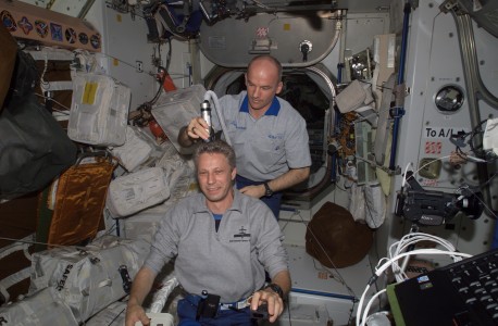 Astronaut Jeffrey N. Williams, Expedition 13 NASA space station science officer and flight engineer, trims astronaut Thomas Reiter's hair in the Unity node of the International Space Station. Williams used hair clippers fashioned with a vacuum device to garner freshly cut hair. Reiter, flight engineer, represents the European Space Agency (ESA).