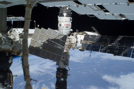 The Russian segment of the International Space Station is featured in this image photographed by a space-walking astronaut during the third and final spacewalk for the STS-129 mission. The Poisk Mini Research Module 2 (MRM2), docked to the space-facing port of the Zvezda Service Module, is at top center; and a Progress resupply vehicle is docked to the Pirs Docking Compartment at bottom center. Zarya (partially obscured by solar panels) is at right center. Earth's horizon and the blackness of space provide the backdrop for the scene.