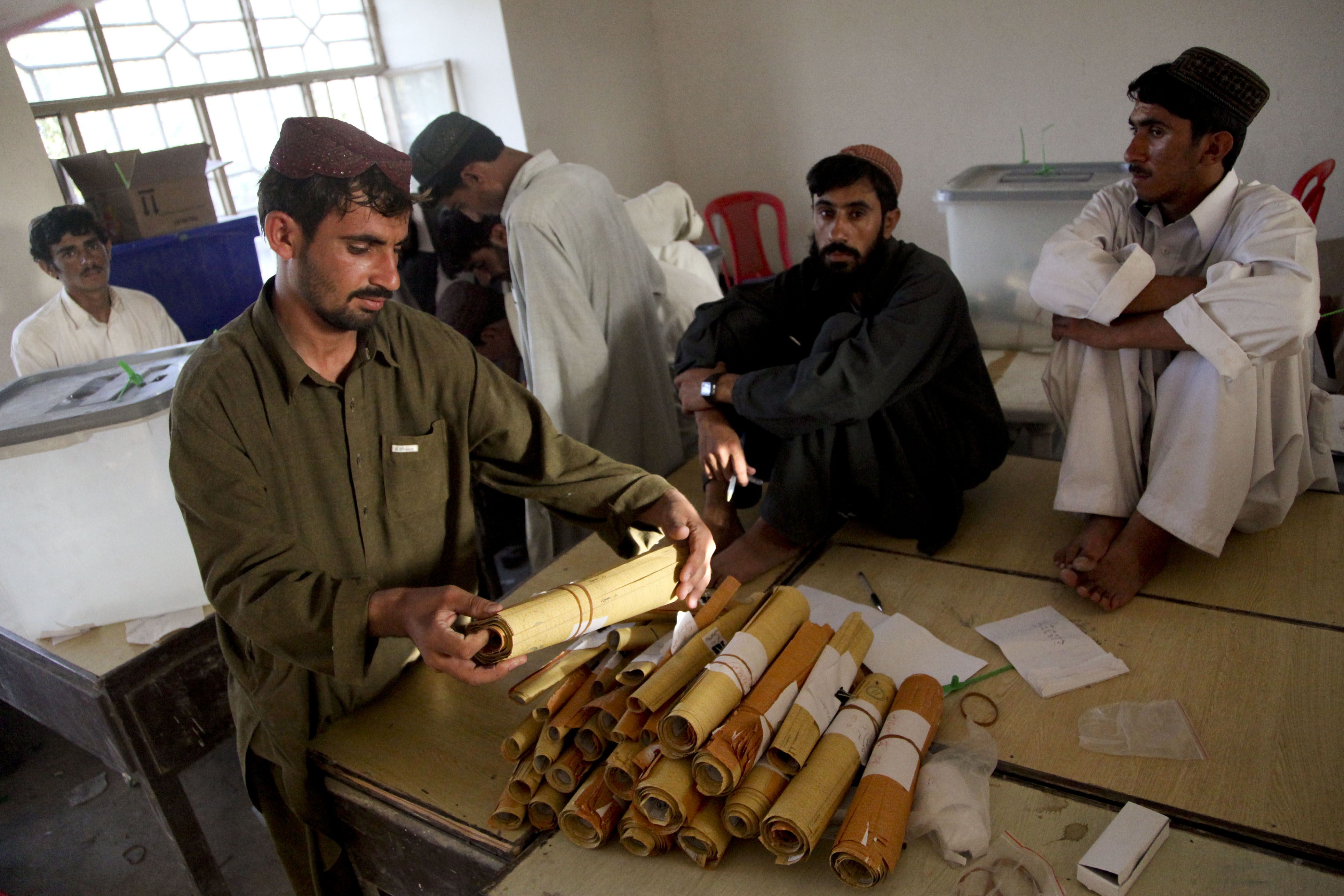 US Navy 090821-M-0440G-031 Afghan presidential election workers count and organize election ballots at a local school in the Nawa District
